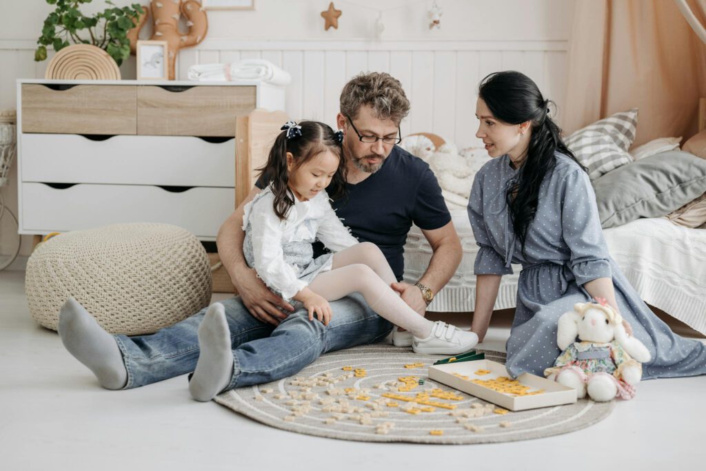 A family enjoying quality time together playing a board game in a cozy living room setting.