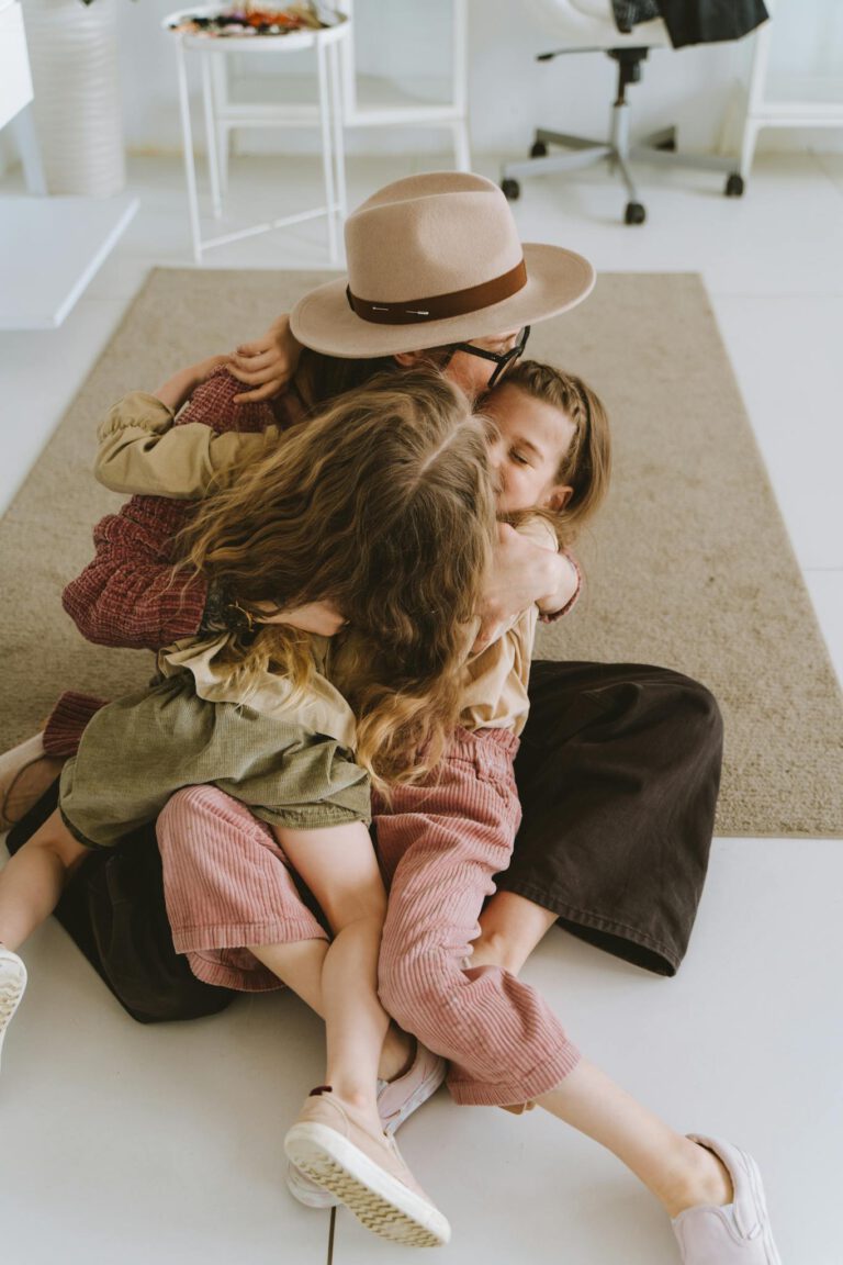 A loving mother embraces her daughters in a warm, joyful moment of family bonding at home.